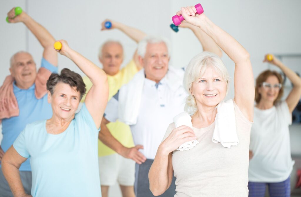 A group of older adults smiling and exercising together.